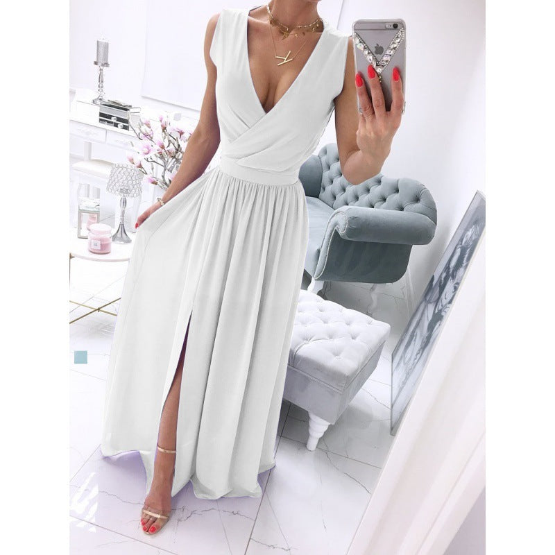 Woman wearing long white V-neck dress with front slit, taking mirror selfie in chic interior