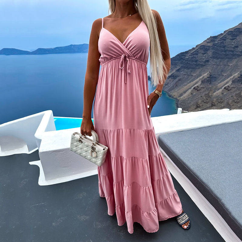 Pastel pink ruffle-hem maxi dress with white handbag, feminine beach outfit