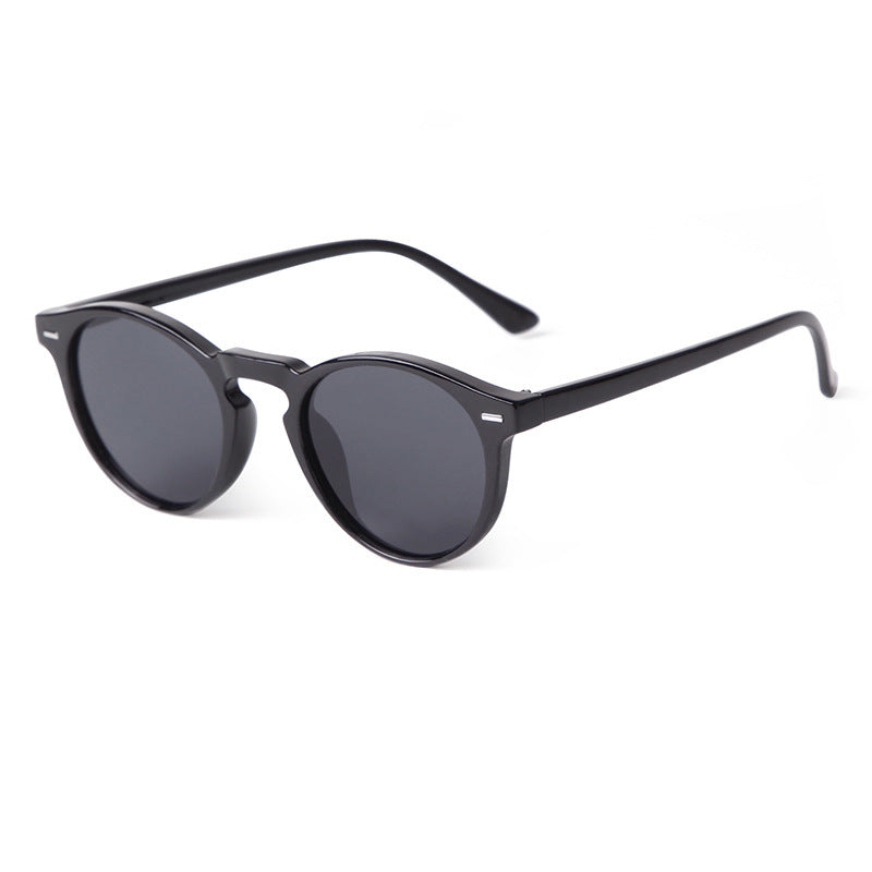 Transparent black sunglasses with dark grey lenses, round shape.