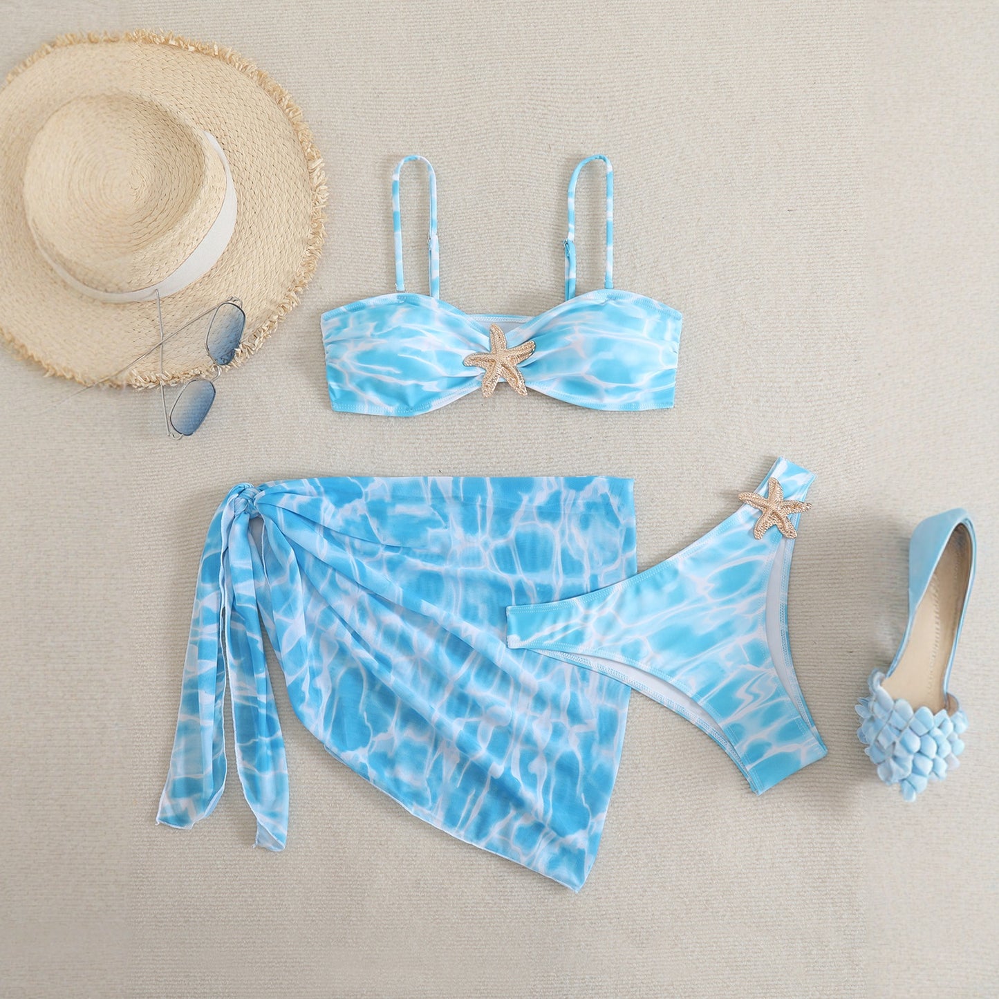 Sininen bikini-setti sarong-hameella ja meritähtiyksityiskohdilla