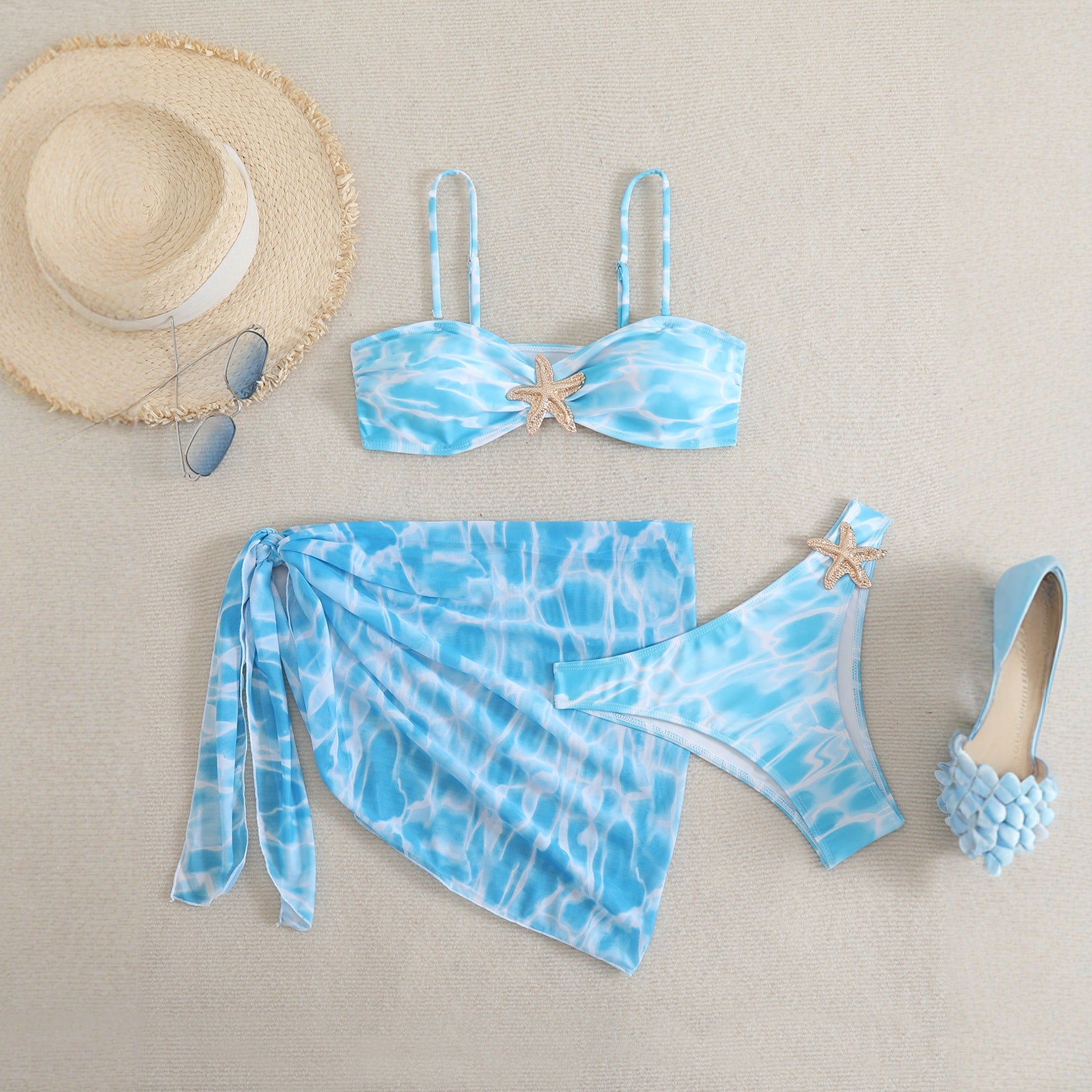 Sininen bikini-setti sarong-hameella ja meritähtiyksityiskohdilla