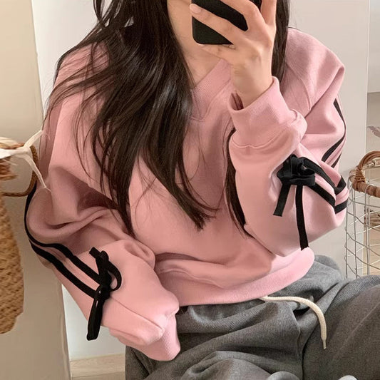 Pink hoodie with ribbon sleeve details – Women’s loose-fit sweatshirt in pink with decorative ribbons.