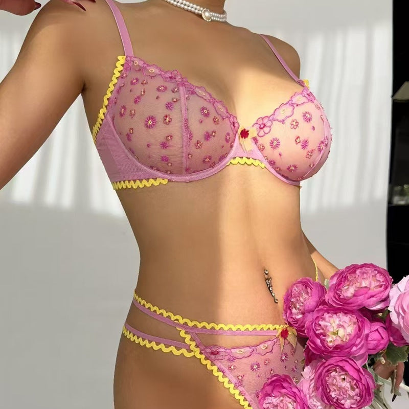 Model wearing pink women's lace lingerie set, light and elegant, posing with flowers