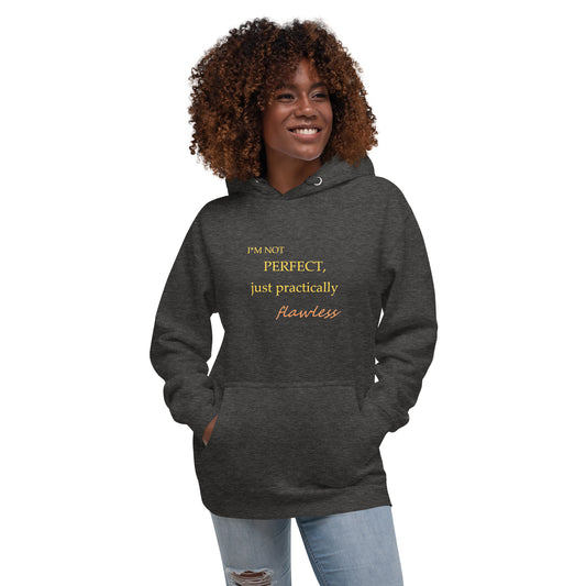 Model wearing a charcoal heather unisex hoodie with "I'm not perfect, just practically flawless" design, hands in pocket, smiling.
