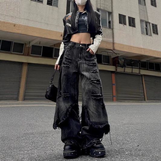 Woman wearing oversized black distressed jeans in street setting