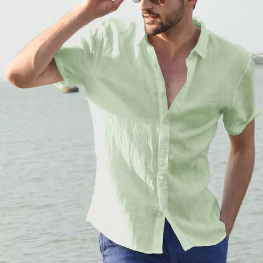 Man wearing a light green short-sleeved summer shirt, casual style, by the water.