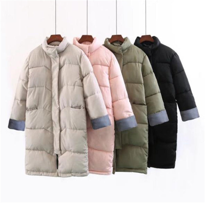 Group of puffer jackets in pink, beige, green, and black hanging on rack