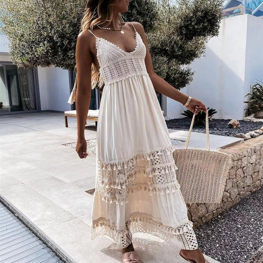 Woman wearing beige boho-style maxi dress with crochet top and wide hem, standing outside in sunlight