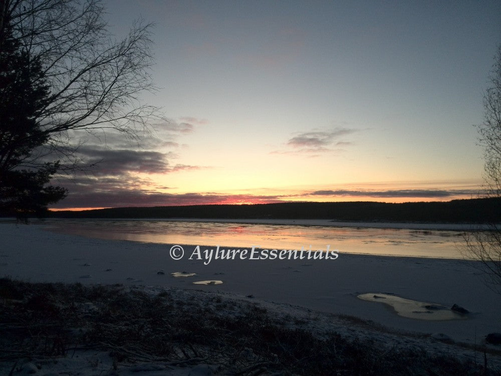Frozen river at sunset with pastel winter sky and icy shoreline – printable photo titled “Frozen Silence” by AylureEssentials.