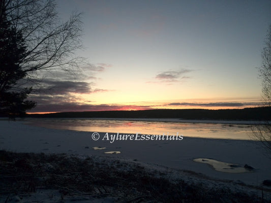 Frozen river at sunset with pastel winter sky and icy shoreline – printable photo titled “Frozen Silence” by AylureEssentials.